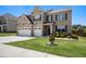 Beautiful two-story home featuring a lush green lawn and an attached two-car garage at 320 Conley Ave, Hampton, GA 30228