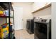 Efficient laundry room with modern washer and dryer units and storage shelving at 320 Conley Ave, Hampton, GA 30228