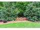 Serene backyard with mature trees, a custom fire pit and lush landscaping at 1610 Turtle Pond Dr, Hoschton, GA 30548