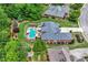 An aerial view shows the backyard with a pool, spa, deck, and lush landscaping with mature trees at 1610 Turtle Pond Dr, Hoschton, GA 30548