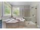 Spa-like bathroom featuring a soaking tub and a separate glass shower at 1610 Turtle Pond Dr, Hoschton, GA 30548