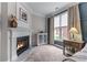 Bedroom featuring a cozy fireplace and natural light from a large window at 1610 Turtle Pond Dr, Hoschton, GA 30548