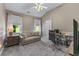 Cozy bedroom with vaulted ceiling, a comfortable sofa, and a workspace illuminated by natural light at 1610 Turtle Pond Dr, Hoschton, GA 30548