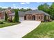 Beautiful brick home featuring a well-manicured lawn, and a large driveway at 1610 Turtle Pond Dr, Hoschton, GA 30548