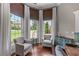 Comfortable home office featuring hardwood floors, bright windows, and two chairs at 1610 Turtle Pond Dr, Hoschton, GA 30548