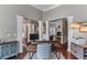 Open home office with hardwood floors, columns, and a glimpse into the living room at 1610 Turtle Pond Dr, Hoschton, GA 30548