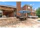 Enjoy outdoor dining with a built-in kitchen, stone patio, and comfortable seating under a large umbrella at 1610 Turtle Pond Dr, Hoschton, GA 30548