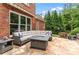 Inviting brick patio featuring a cozy seating area with a fire pit and stone flooring at 1610 Turtle Pond Dr, Hoschton, GA 30548