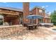 Outdoor patio with an outdoor kitchen, dining set, and lounge area on a stone patio in a brick home at 1610 Turtle Pond Dr, Hoschton, GA 30548