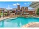 Inviting in-ground pool with a waterfall feature and an outdoor seating area, perfect for relaxation and entertaining at 1610 Turtle Pond Dr, Hoschton, GA 30548