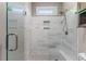 Sleek tiled shower with glass enclosure, rain shower head, and built-in niche for bath essentials at 1610 Turtle Pond Dr, Hoschton, GA 30548