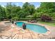 Gorgeous in-ground pool area with stone decking and lush landscaping at 1610 Turtle Pond Dr, Hoschton, GA 30548