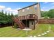 View of the home's back exterior featuring a wooden deck with staircase and walkout basement access at 1955 Piedmont Cove Ln, Cumming, GA 30040
