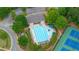 Overhead view of a community pool with sun loungers and shade umbrellas by the tennis courts at 1955 Piedmont Cove Ln, Cumming, GA 30040