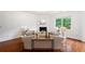 Bright living room features a fireplace, hardwood floors, neutral decor and large windows overlooking lush greenery at 1955 Piedmont Cove Ln, Cumming, GA 30040