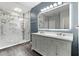 Modern bathroom with double sink vanity, decorative mirror, and frameless glass shower with marble-look surround at 3 Tiffany Trce, Palmetto, GA 30268