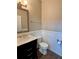 Powder room featuring wainscoting, a dark vanity with a marble countertop and wood-look floors at 3 Tiffany Trce, Palmetto, GA 30268