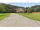 Inviting home with a long driveway leading to a manicured front lawn and trees at 3 Tiffany Trce, Palmetto, GA 30268
