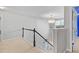 Upstairs hallway with neutral paint and carpet features railing and a chandelier at 3 Tiffany Trce, Palmetto, GA 30268