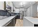 Modern kitchen features white and navy cabinets, stainless appliances, quartz countertops, and designer lighting at 3 Tiffany Trce, Palmetto, GA 30268