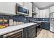 Bright kitchen features white and navy cabinets, stainless appliances, quartz countertops, and designer backsplash at 3 Tiffany Trce, Palmetto, GA 30268