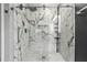 Frameless glass shower features marble-look surround with designer fixtures and custom storage solutions at 3 Tiffany Trce, Palmetto, GA 30268
