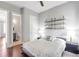 Bedroom with hardwood floors, floating shelves, ceiling fan, and view into ensuite bathroom at 3179 Falls Crest Ct, Buford, GA 30519