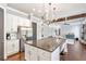 Kitchen with a large island, stainless steel refrigerator, and modern pendant lighting at 3179 Falls Crest Ct, Buford, GA 30519