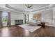 Spacious main bedroom with a ceiling fan, hardwood floors, headboard decor, and large window at 3179 Falls Crest Ct, Buford, GA 30519