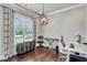 Bright office space featuring hardwood floors, modern light fixture, and large window with decorative curtains at 3179 Falls Crest Ct, Buford, GA 30519