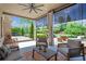Covered patio with comfortable seating, outdoor fan, and a view of the landscaped backyard at 3179 Falls Crest Ct, Buford, GA 30519