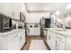 Well-lit kitchen with stainless steel appliances, white cabinetry, and lots of counter space at 450 Rockfern Ct, Lilburn, GA 30047