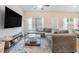 Spacious living room featuring a large sectional sofa, TV, and large windows at 450 Rockfern Ct, Lilburn, GA 30047