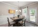 Dining area featuring gray laminate flooring, modern chandelier, and access to the backyard at 213 Yellowwood Way, Woodstock, GA 30188