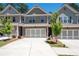 Beautiful townhome showcasing a two-car garage, brick accents, and a meticulously maintained front lawn at 213 Yellowwood Way, Woodstock, GA 30188