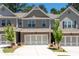 Charming townhome with a two-car garage, neutral siding, and a well-manicured front yard at 213 Yellowwood Way, Woodstock, GA 30188