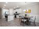Open concept living area with kitchen, dining, and living room featuring modern decor and gray laminate flooring at 213 Yellowwood Way, Woodstock, GA 30188