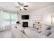 Comfortable living room with ceiling fan, fireplace, large windows, and modern decor for a cozy space at 213 Yellowwood Way, Woodstock, GA 30188