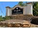 Stone and brick sign for the Park at Camden community is surrounded by trees and shrubbery at 213 Yellowwood Way, Woodstock, GA 30188