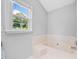 Bright bathroom features a soaking tub, tile surround, and a window with a view to the outside at 3405 Haverhill Rowe, Lawrenceville, GA 30044