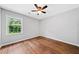 Bedroom with hardwood floors, ceiling fan, and sun-filled window with a view of the yard at 3405 Haverhill Rowe, Lawrenceville, GA 30044