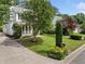 View of a landscaped front yard featuring lush green lawn, trees, shrubs, and decorative mailbox on a sunny day at 3405 Haverhill Rowe, Lawrenceville, GA 30044