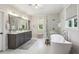 Bright bathroom featuring a soaking tub, glass shower, and dual sink vanity with white marble floors at 3617 Carson Se Ln, Smyrna, GA 30080