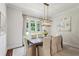 Elegant dining room with a wooden table, upholstered chairs, and stylish light fixture, bathed in natural light at 3617 Carson Se Ln, Smyrna, GA 30080