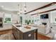 Bright kitchen with a large island, modern lighting, and stainless steel appliances, seamlessly connecting to the living area at 3617 Carson Se Ln, Smyrna, GA 30080