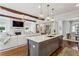 Open concept kitchen and living area with a large island, wooden beams, fireplace, and ample natural light at 3617 Carson Se Ln, Smyrna, GA 30080