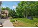 Expansive backyard featuring a trampoline, mature trees, landscaping, and patio area at 641 Lake Overlook Dr, Canton, GA 30114