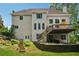 Back of the house with a large deck and landscaped backyard featuring stone steps and retaining walls at 641 Lake Overlook Dr, Canton, GA 30114