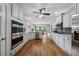 Well-lit kitchen with stainless steel appliances, white cabinets, and a large center island and hardwood floors at 641 Lake Overlook Dr, Canton, GA 30114