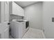 Bright laundry room featuring a white washer and dryer, white cabinets and stylish patterned flooring at 641 Lake Overlook Dr, Canton, GA 30114